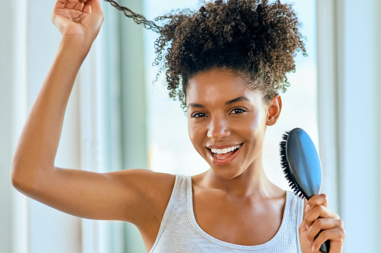 Applying pre-poo treatment to natural hair to reduce breakage before shampooing.